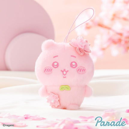 Pink plush mascot with hanging loop, flower accents, and cute embroidered face