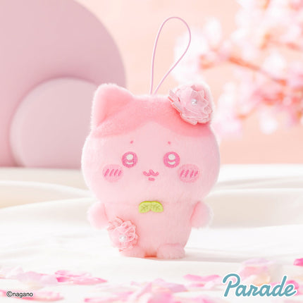 Pink plush mascot with hanging loop and embroidered face, small flower on head