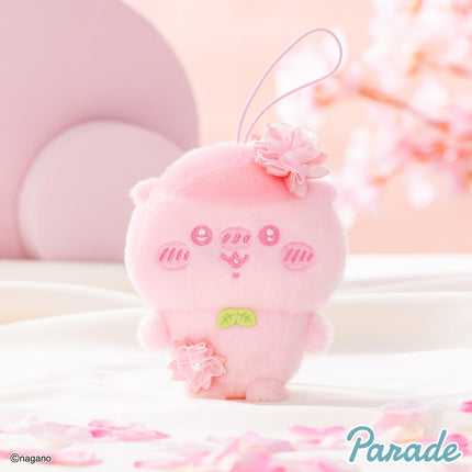 Pink plush mascot with hanging loop and embroidered face, flower on top