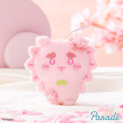 Pink plush mascot with hanging loop, round paws, and embroidered smiley face