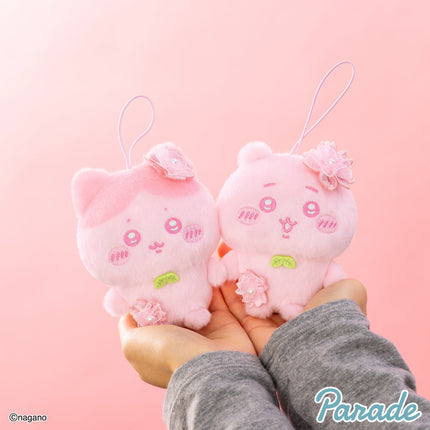 Pink Chiikawa plush mascot with hanging loop and flower details, held in hands