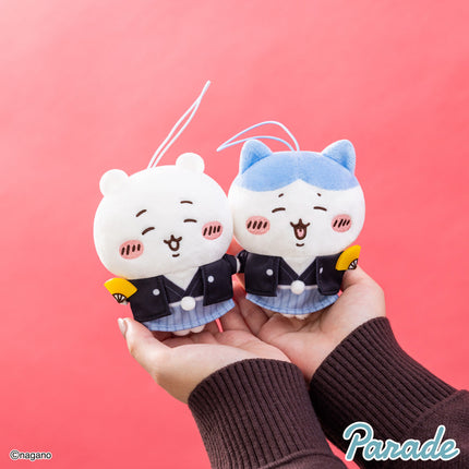 New Year mascot plush pair held in hands: white and blue faces in black jackets