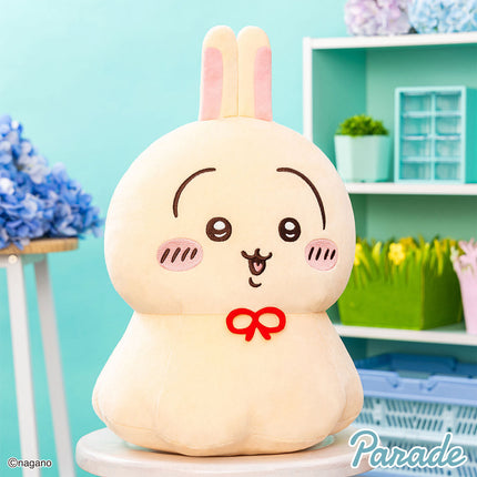 Cream bunny plush toy with pink ears, smiling face, and red bow, seated