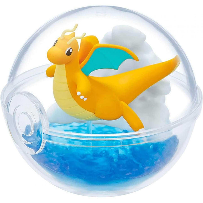 A figurine of a dragon-like creature with yellow and blue colors, resembling a Pokémon or similar Pokémon character, is depicted inside a transparent ball-shaped container filled with blue water.