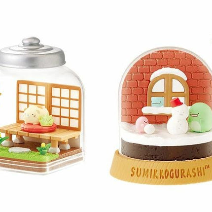 two snow globes, one with a traditional Japanese-style scene and the other with a more whimsical scene.