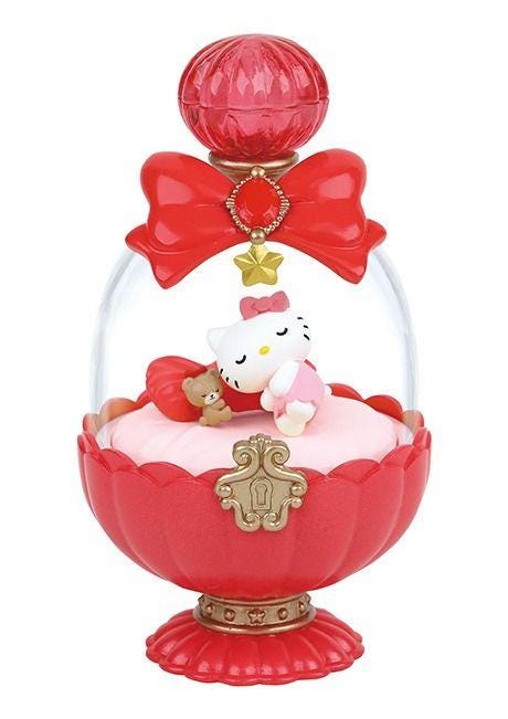 A Hello Kitty perfume bottle with a red and gold design, featuring a sleeping Hello Kitty doll inside a glass dome.