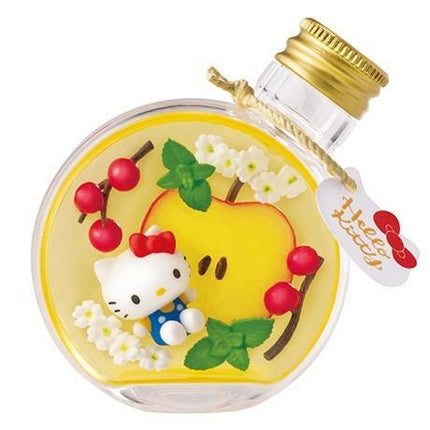 A Hello Kitty perfume bottle with a yellow body and a gold cap, decorated with a variety of colorful elements such as flowers, cherries, and leaves.