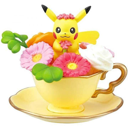 A yellow teacup with a pink flower and a yellow flower inside, along with a yellow teapot and a yellow teacup.