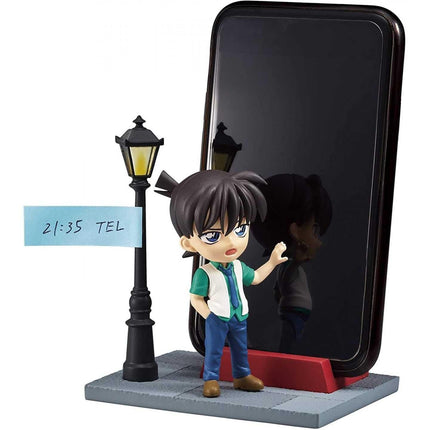 A figurine of a young boy standing next to a smartphone, with a street lamp and a sign indicating the time.
