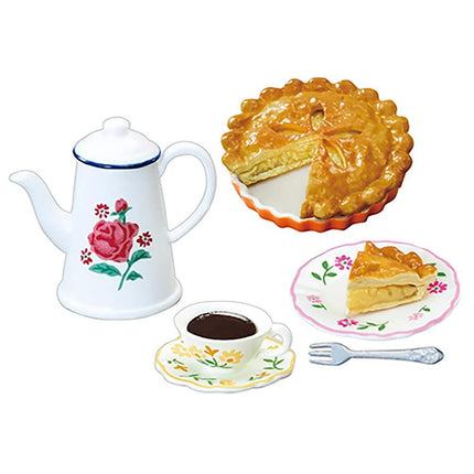 A tea set with a teapot, a cup of tea, a slice of pie, and a fork on a white background.