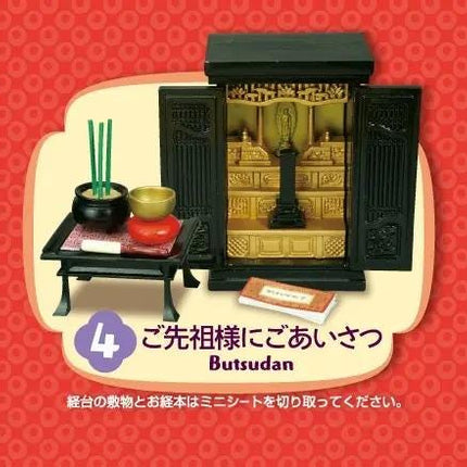 A miniature shrine with a black door, gold accents, and a small statue inside, along with a small table and a book. The shrine appears to be a religious or spiritual object, possibly representing the concept of Butsudan, a traditional Japanese shrine.