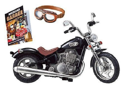 a black motorcycle with a leather seat, goggles, and a magazine titled "American Garage" on a white background.