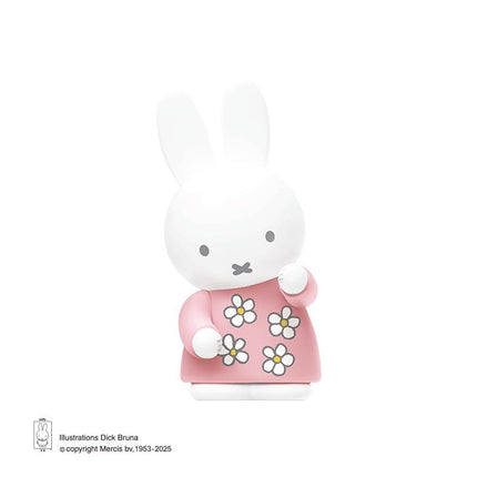 A white bunny figurine wearing a pink dress with white flowers.