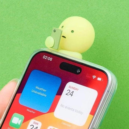 A hand holding a smartphone with colorful app icons on the screen against a green background.