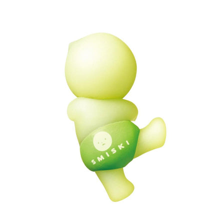 A small, yellow figurine with a face and the word "SMISKI" printed on it.
