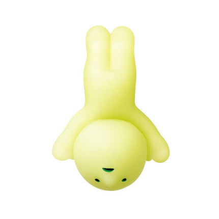 A yellow, cartoon-like figure with green eyes and a green nose is shown upside down against a white background.