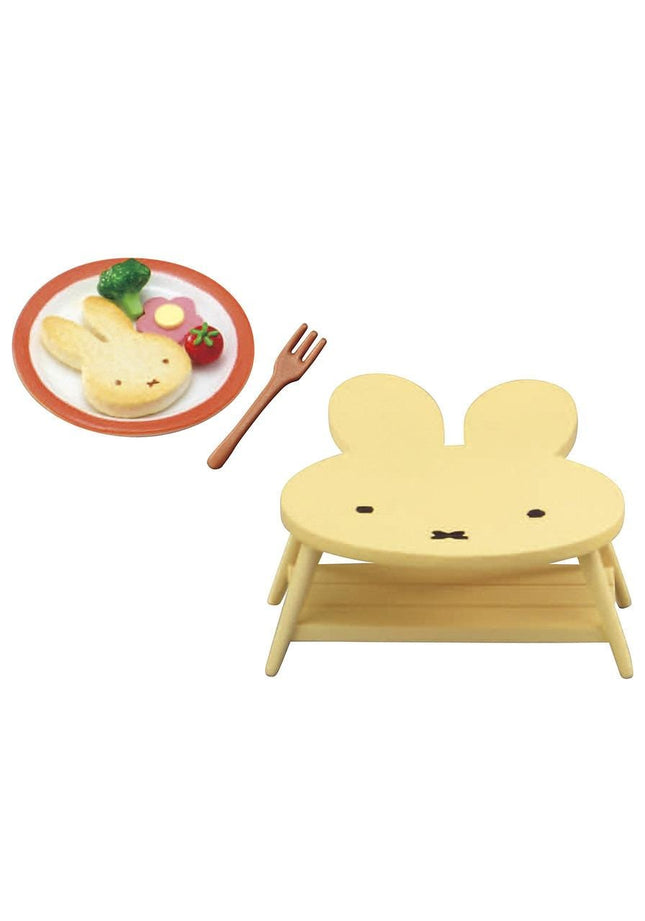 a yellow rabbit-shaped high chair with a plate of food, including broccoli, a fork, and a strawberry.