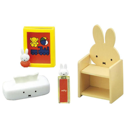 a variety of small toys, including a wooden chair, a tissue box, a small toy train, and a small toy rabbit.