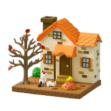 A small toy house with a tree and a dog figurine in front of it, set against a white background.