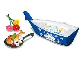 A blue and white boat-shaped toy with a frying pan and a plate of food on it, along with some flowers.