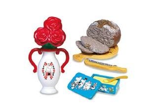 a vase with red roses, a loaf of bread, a wooden cutting board, a blue container, and a yellow spoon.