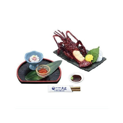 a variety of food items and utensils, including a large cooked lobster, a small bowl of sauce, chopsticks, and a plate with a green leaf and other garnishes.