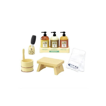 a set of three bottles of soap and shampoo, a wooden stool, a wooden spoon, and a white towel.