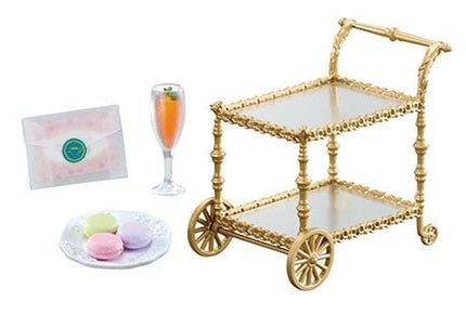 a gold-colored two-tiered cart with a glass of champagne, a plate of pastries, and a small glass of orange juice.