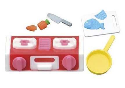 various toy kitchen accessories, including a toy stove, a toy knife, a toy fish, a toy carrot, and a toy frying pan.
