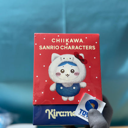 A person is holding a box of "Chikawa Sanrio Characters" with a character wearing a blue outfit and a red bow.