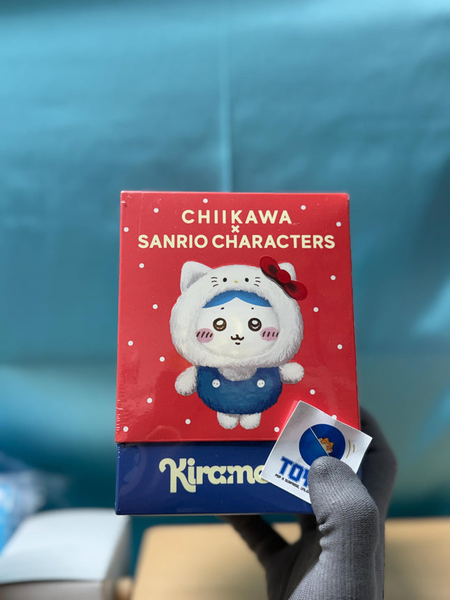 A person is holding a box of "Chikawa Sanrio Characters" with a character wearing a blue outfit and a red bow.