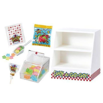 various candy items, including a candy dispenser, candy bags, and a clear container filled with colorful gummy candies.