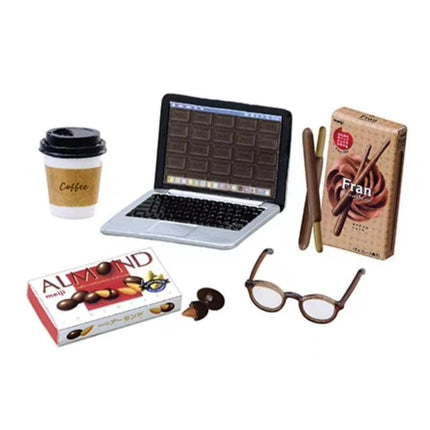 a laptop, a coffee cup, a box of almonds, a pair of glasses, and a box of Fran chocolate.