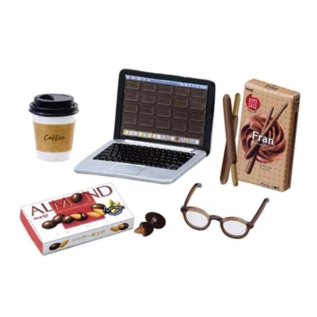 a laptop, a coffee cup, a box of almonds, a pair of glasses, and a box of Fran chocolate.