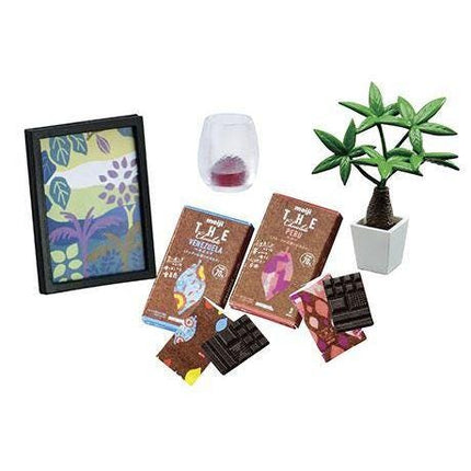 various items, including a framed picture, a potted plant, chocolate bars, and a glass candle holder.