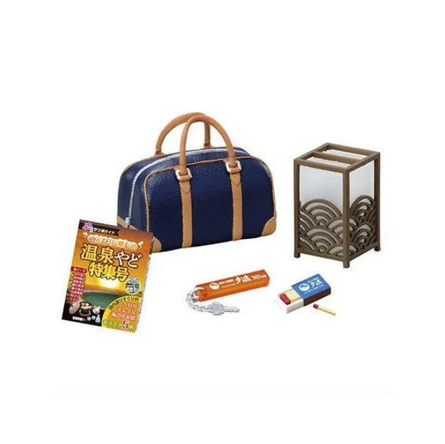 a blue handbag, a book, a keychain, a matchbox, and a small lamp.