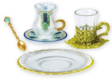 a set of glassware, including a cup, a saucer, and a glass, all with intricate designs and gold accents.