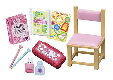 A collection of various children's toys and items, including a pink ribbon, a book, stickers, a pencil case, and a chair.