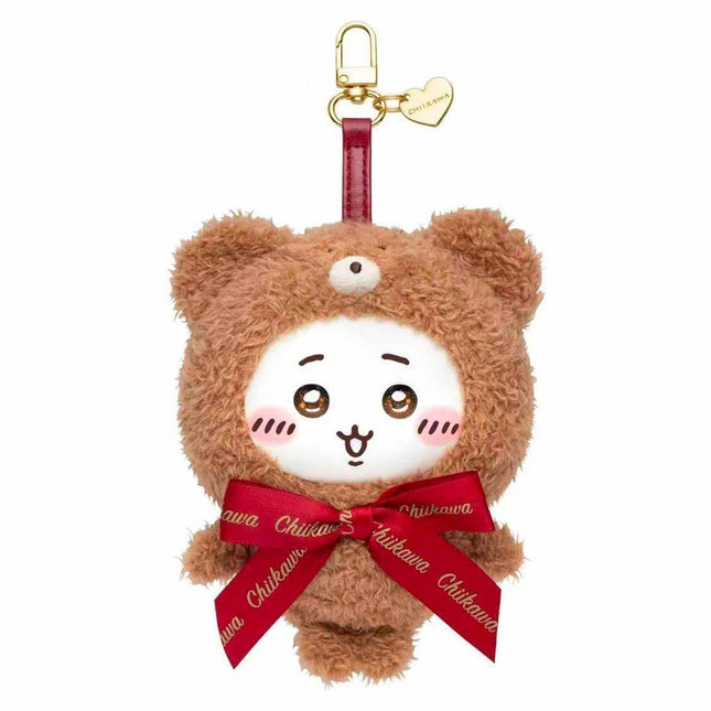 A plush toy of a brown bear wearing a red ribbon and a heart-shaped tag.