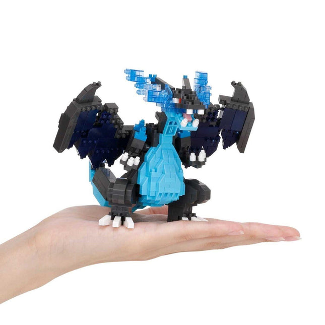 A hand holding a small blue and black LEGO dragon toy.