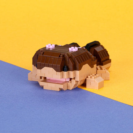 A small, brown and beige Lego frog is sitting on a blue and yellow background.