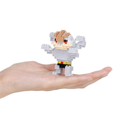 A hand holding a small, pixelated toy figure.