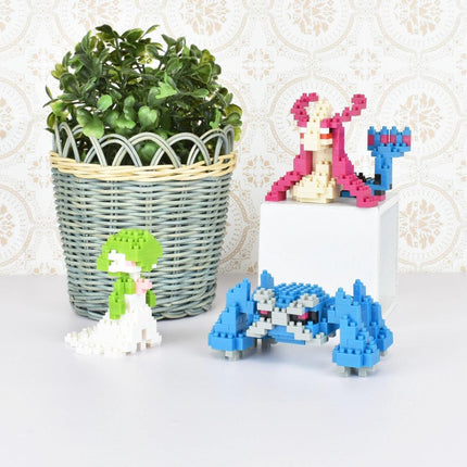 a variety of colorful, small toys and a potted plant on a white surface.