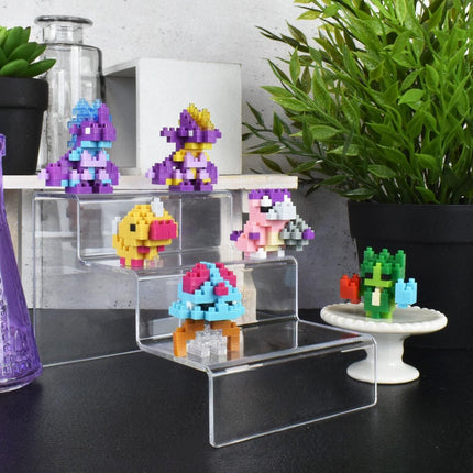 a collection of colorful, pixelated figurines displayed on clear shelves, with a potted plant and other decorative items in the background.