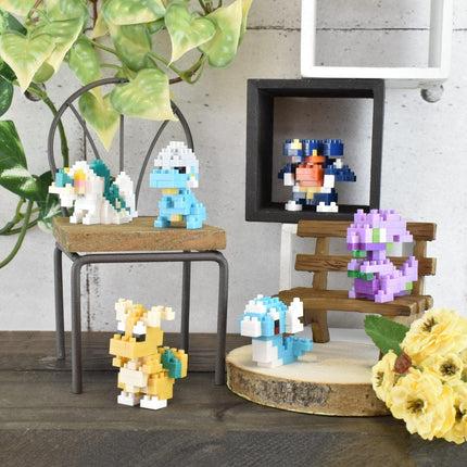 a collection of colorful, pixelated figurines arranged on a wooden surface, with a potted plant and a wooden bench in the background.