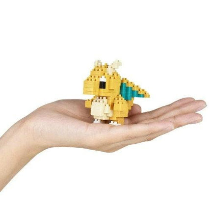 A hand holding a small yellow and green pixelated dragon figure.