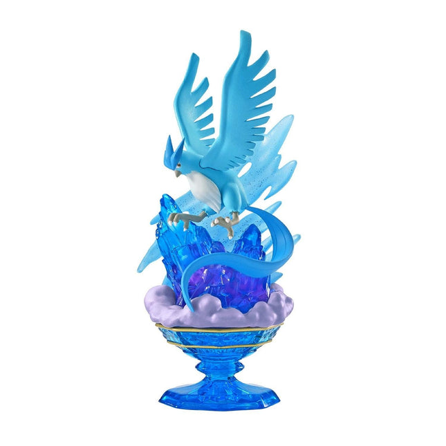 A figurine of a blue bird-like creature with wings and talons, perched on a blue crystal base with a cloud-like shape.
