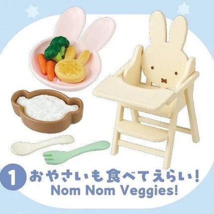 A wooden high chair with a small bowl of vegetables, a spoon, and a fork, along with a sign that says "Nom Nom Veggies!"