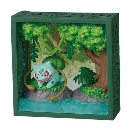A green box containing a miniature diorama depicting a Pokémon character surrounded by a lush, green forest environment.