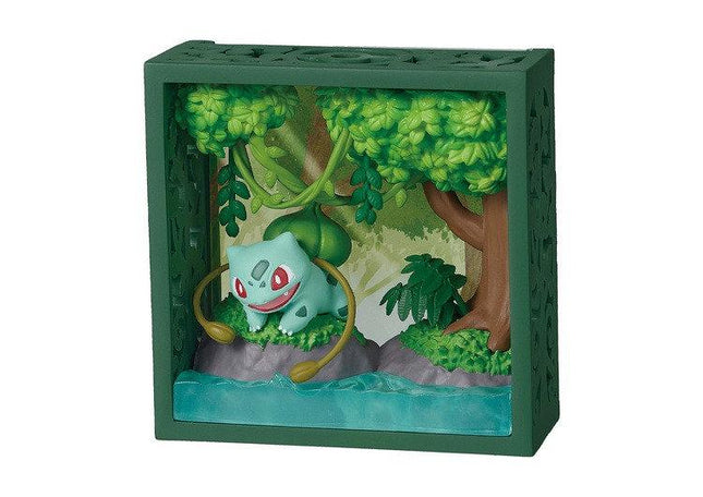 A green box containing a miniature diorama depicting a Pokémon character surrounded by a lush, green forest environment.